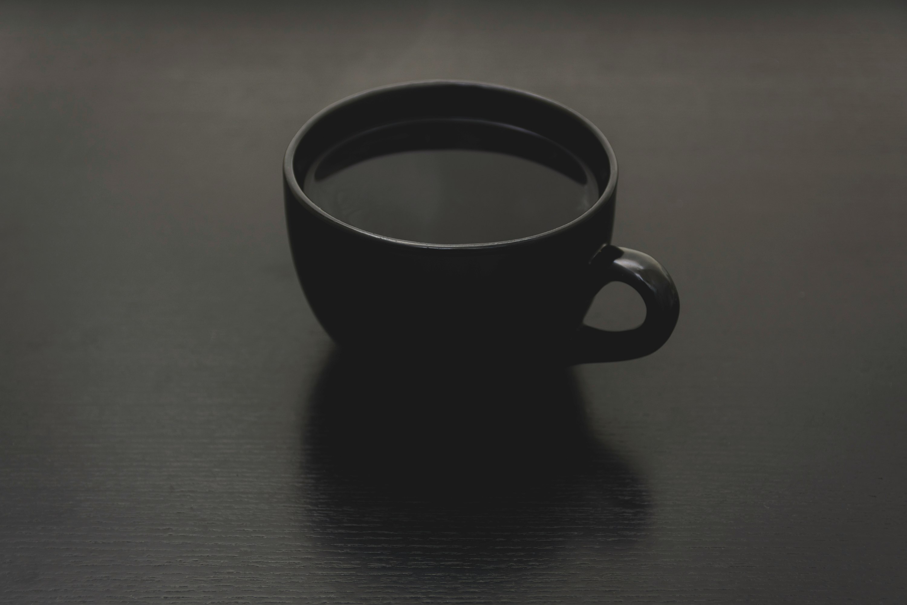 black ceramic mug with liquid close up photo